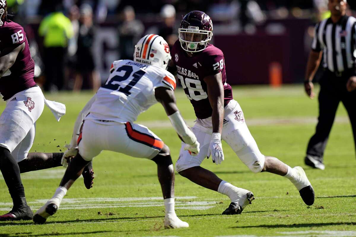 Texas A&M running back Isaiah Spiller (28) rushes for a gain as Auburn safety Smoke Monday (21) defends during the first half of an NCAA college football game Saturday, Nov. 6, 2021, in College Station, Texas. (AP Photo/David J. Phillip)
