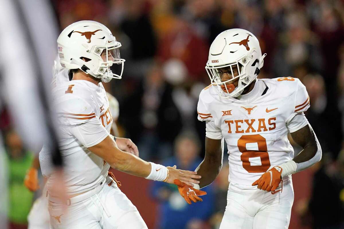 Texas wide receiver Xavier Worthy (8) celebrates with teammate quarterback Hudson Card (1) after catching a 4-yard touchdown pass during the first half of an NCAA college football game against Iowa State, Saturday, Nov. 6, 2021, in Ames, Iowa. (AP Photo/Charlie Neibergall)