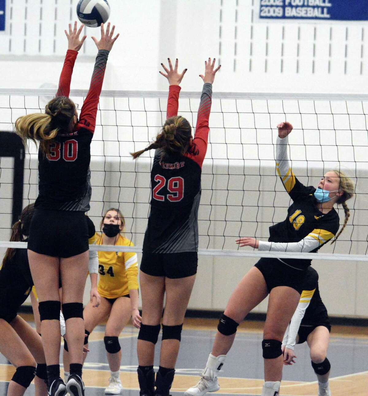 Cheshire’s Eva Catalonotto (30) blocks a shot by Amity’s Mya DiZenzo in the SCC girls’ volleyball championship game Saturday night in West Haven.