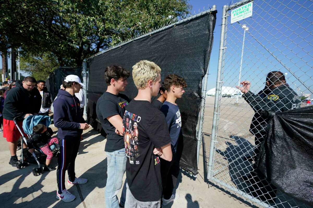 People line up at gate along Westridge St. at Kirby Dr. in NRG Park to enter to go to a tent to retrieve items left behind after attending Saturday’s Astroworld Festival featuring Travis Scott Sunday, Nov. 7, 2021 in Houston. Eight were killed and multiple people were injured as Travis Scott was performing at Saturday’s Astroworld Festival.