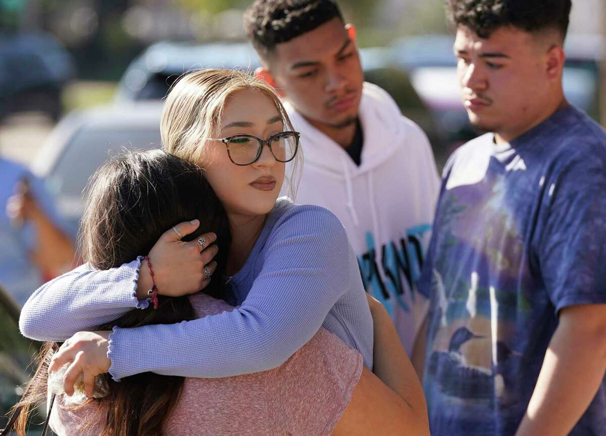 Alyssa Cortes, center, hugs a friend as they view the Astroworld Festival memorial items along Westridge St. at Kirby Dr. in NRG Park Sunday, Nov. 7, 2021 in Houston. She said she and her friends attended the festival and had a difficult time getting out. Eight were killed and multiple people were injured as Travis Scott was performing at Saturday’s Astroworld Festival.
