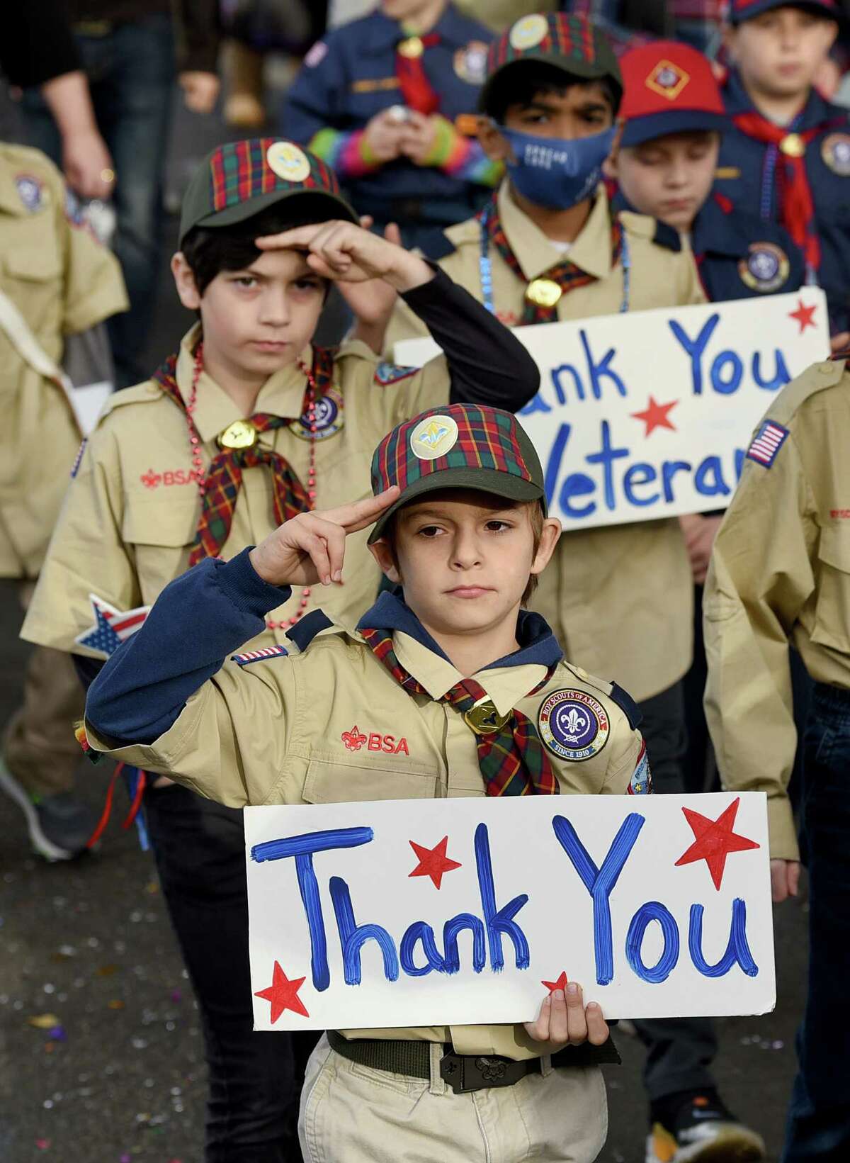 Holding signs to thank veterans, Joseph Grailich, 10, left, and Marco Antonucci, 9, center, march with other members of Milford’s Cub Scout Pack 7 in the annual Veterans Day parade Sunday, Nov. 7, 2021.
