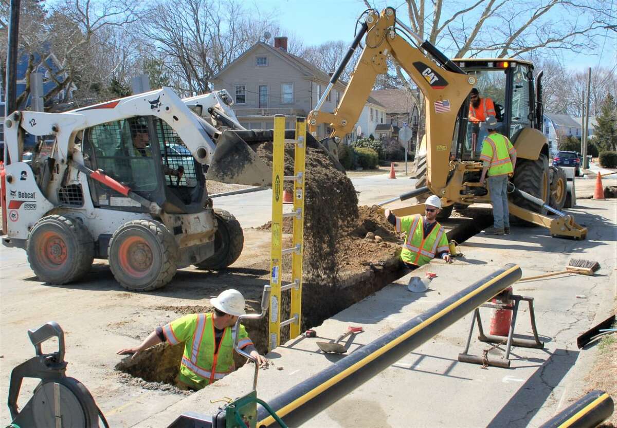 Utility workers from Eversource Energy work on a trench for a natural gas main.