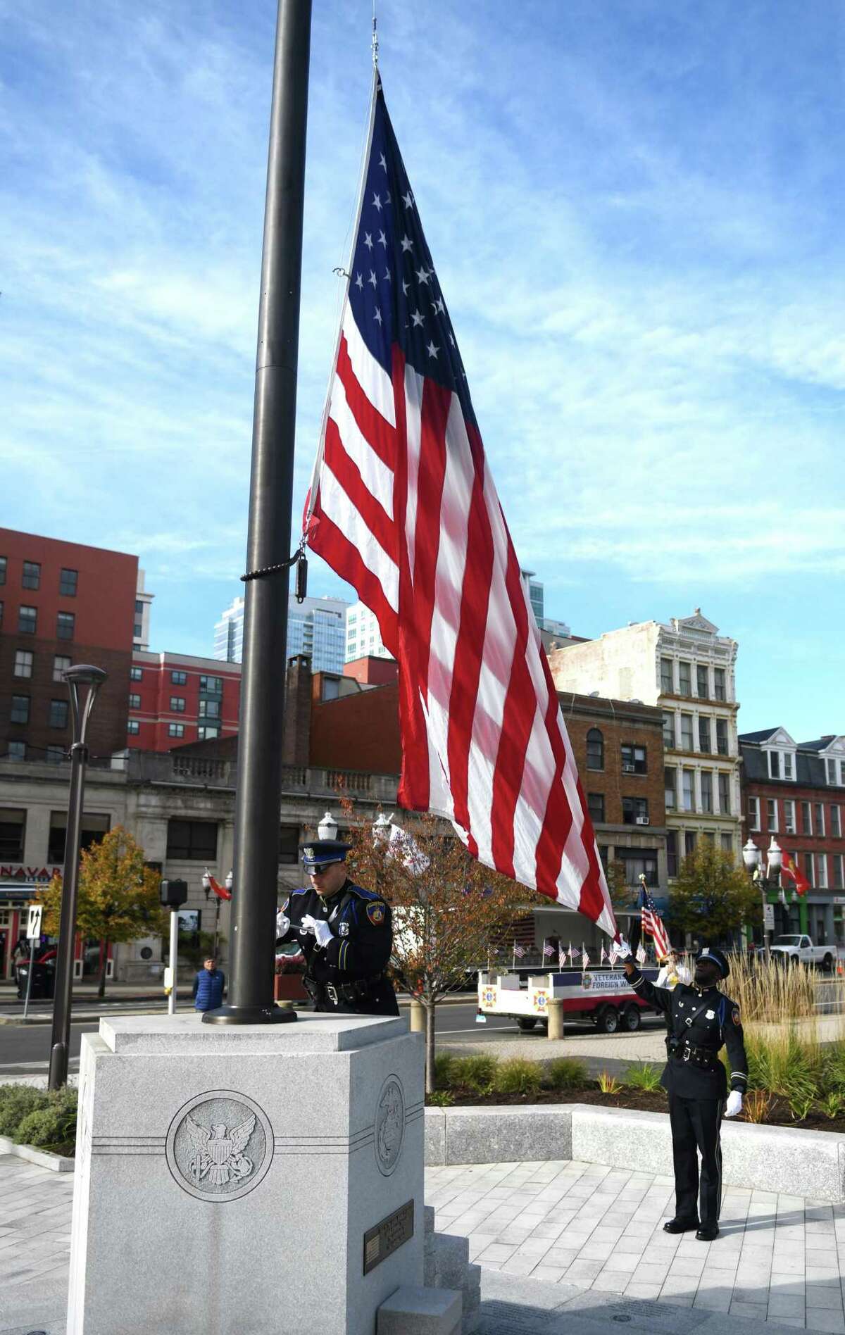 Stamford police Officer Nicholas Kuhn, photo left, raises the flag at the Veterans Day Ceremony at Veterans Memorial Park in Stamford on Sunday. Top right, U.S. Army Sgt. Hubert Delany serves as host of the ceremony while Stamford firefighter Rich LoRusso, above, salutes the flag. Following the parade, the ceremony honored the grand marshal, U.S. Navy Petty Officer Third Class James L. Dudley Jr. (Ret.), and Stamford’s Purple Heart recipients. Mayor David Martin announced Stamford as a Purple Heart City and added it to the Purple Heart Trail. The city of Stamford, Patriotic and Special Events Commission, Veterans Park Partnership, and local veterans’ groups partnered to host the parade and ceremony.