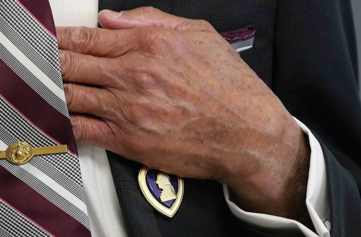 Marine Corps veteran Robert James Briggs, 77, puts his hand over the Purple Heart after a ceremony at Veterans of Foreign Wars Post 8541 in front of fellow veterans and family on Monday.