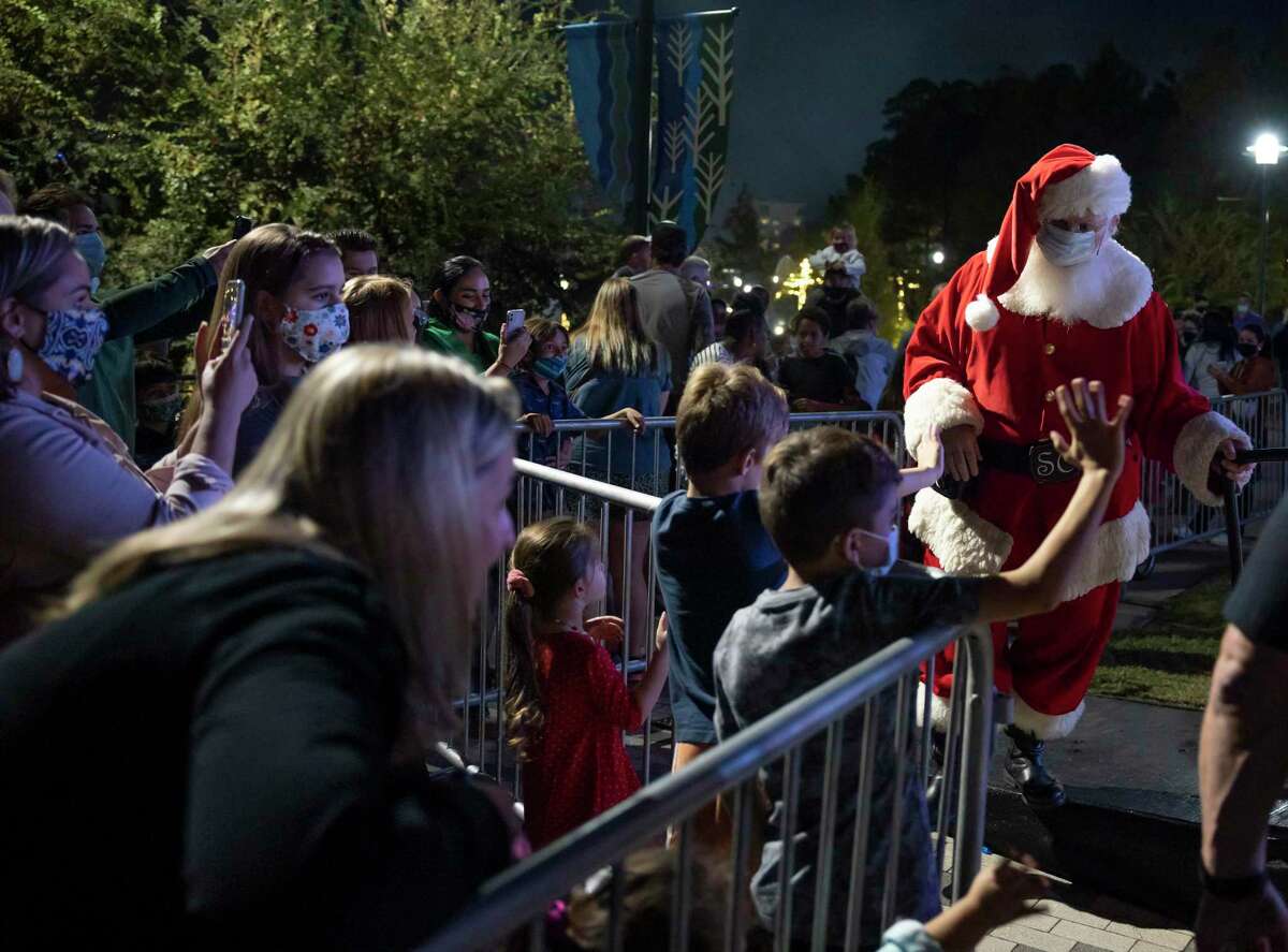 Children wave bye to Santa Claus as he leaves the 38th annual Lighting of the Doves festival at Town Green Park, Saturday, Nov. 21, 2020, in The Woodlands. This year's event was modified due to COVID-19 and did not feature vendors, activities, snow play areas and concessions.
