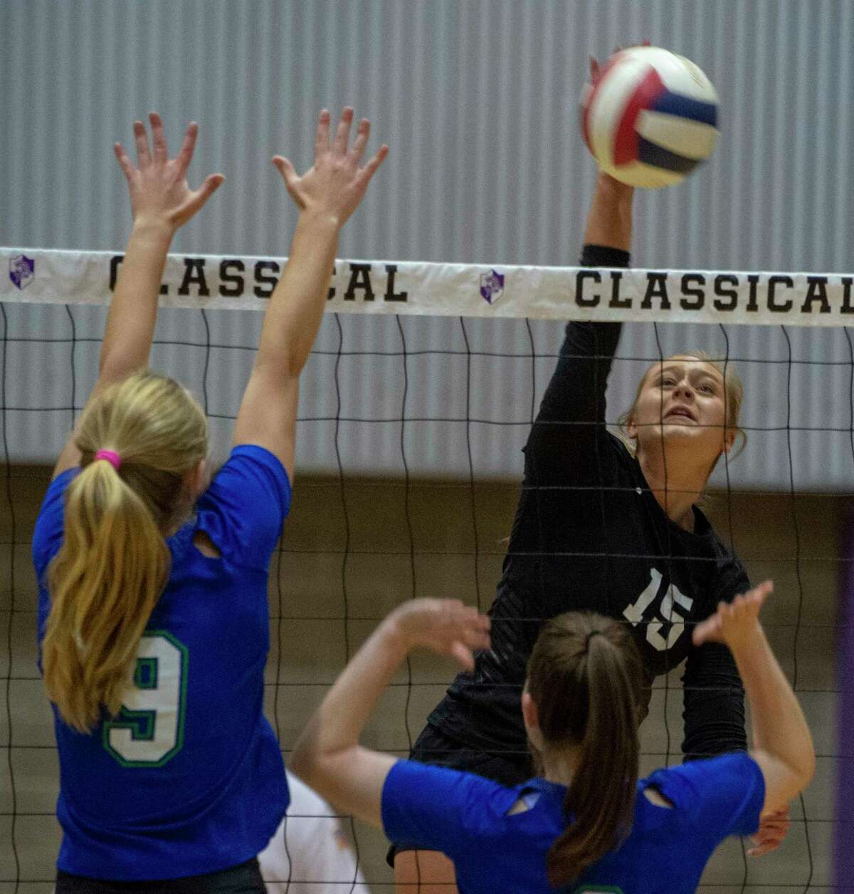Midland Classical's Paytan Parham goes up for a kill as Dallas Lakehill's Hannah Reister and Sydney Rutherford try to block 11/08/2021 at Midland Classical Academy gym. Tim Fischer/Reporter-Telegram