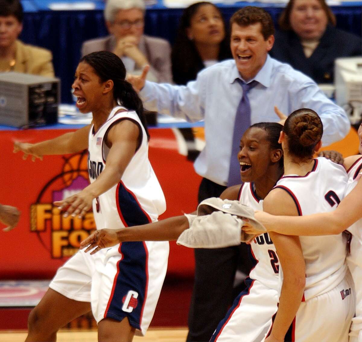 Jessica Moore, from left, head coach Geno Auriemma, Ashley Battle and Diana Taurasi rush the court as time expires against OU at the Alamodome in San Antonio Sunday, March 31, 2002. UConn won 82-70 for the national championship. BAHRAM MARK SOBHANI/STAFF
