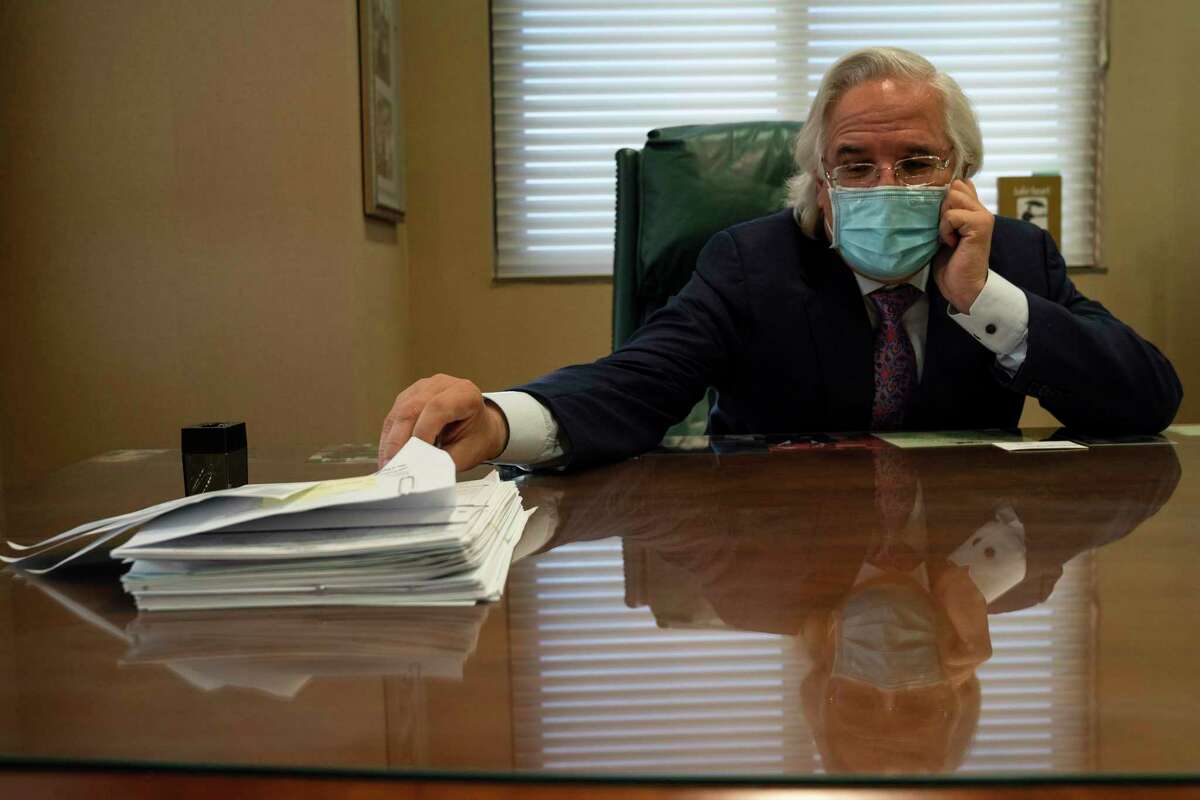 Dr. Ricardo Cigarroa, a cardiologist, with death certificates he had to sign at his office at the Laredo Medical Center in Laredo, Texas, Jan. 27, 2021.
