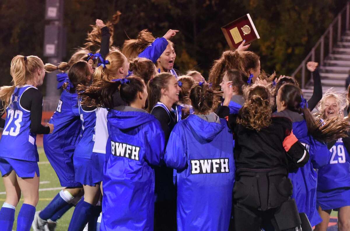 The Darien field hockey team celebrates after defeating New Canaan for the FCIAC championship in Norwalk on Thursday, Nov. 4, 2021.
