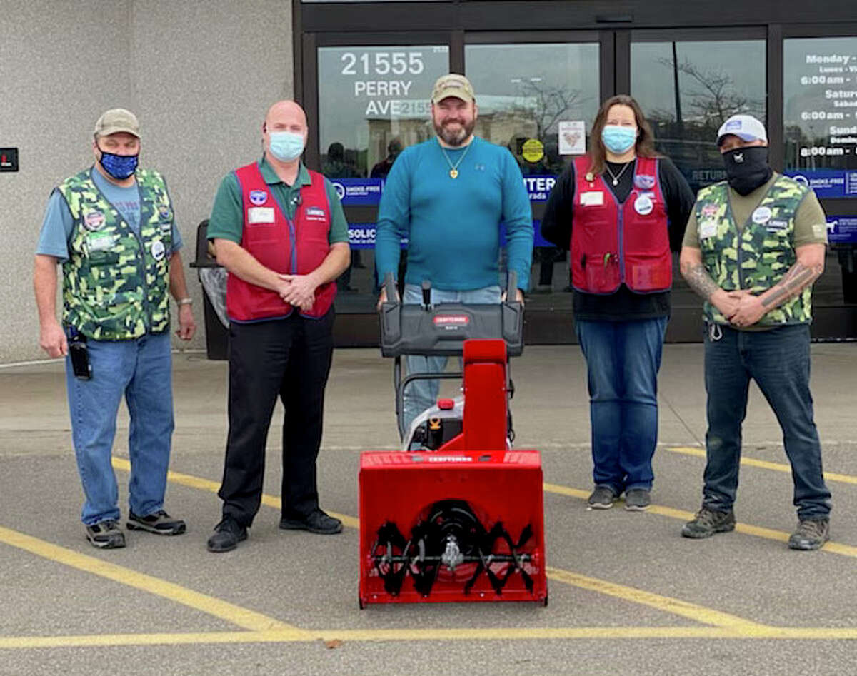 Russ Nehmer, center, is surrounded by employees from the Big Rapids Lowe's as they present him with a new Craftsman snowblower.
