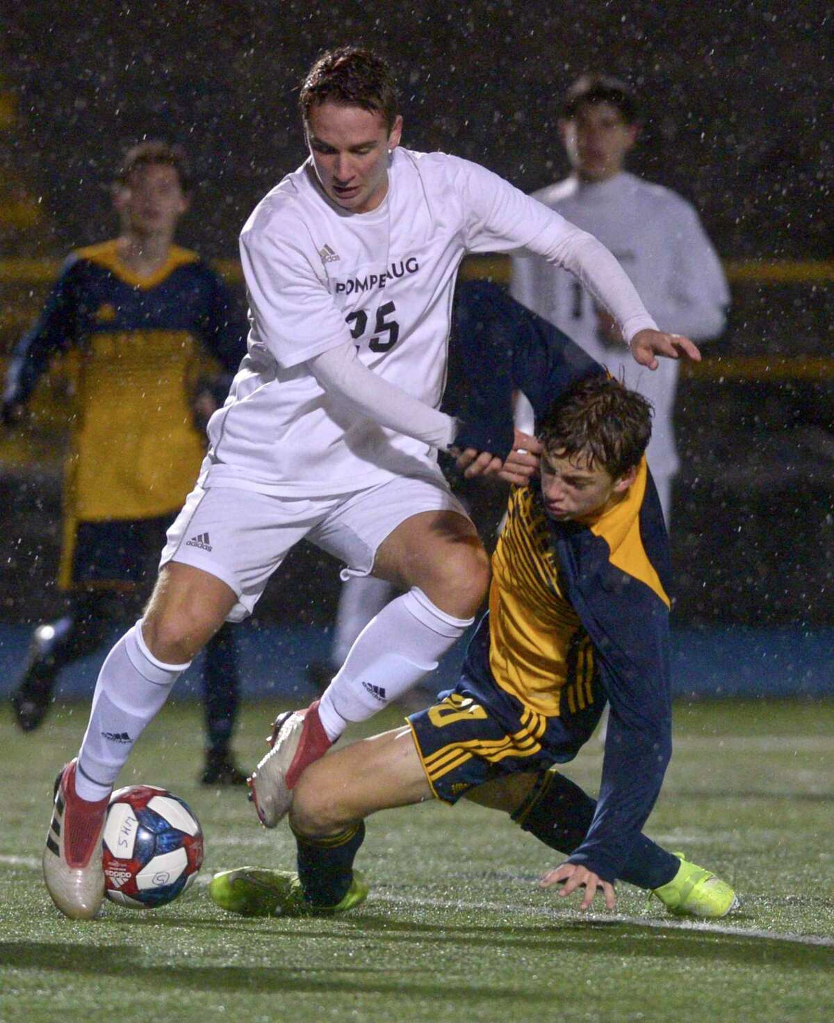 Weston's Max Weiss (20) goes down during a collision with Pomperaug's Eric Tolin (25) in the SWC boys soccer championship game between Pomperaug and Weston high schools. Thursday night, November 7, 2019, at Newtown High School, Newtown, Conn.