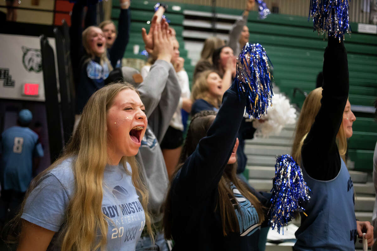 Meridian sophomore Rileigh Smith cheers from the student section during the Mustangs' regional semifinal loss to McBain Tuesday, Nov. 9, 2021 at Houghton Lake High School. (Katy Kildee/Midland Daily News)