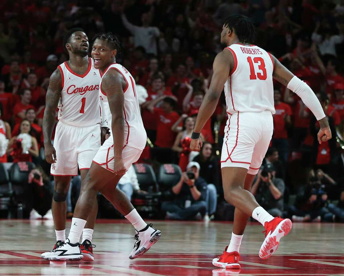 Houston Cougars players Jamal Shead, from left, Marcus Sasser and J'Wan Roberts celebrate the team catching up on Hofstra Pride during overtime of the game Tuesday, Nov. 9, 2021, at Fertitta Center in Houston. The Cougars defeated the Pride 83-75 in overtime.