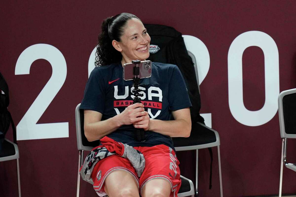 United States' Sue Bird uses her phone to take video of teammates during a women's basketball practice at the 2020 Summer Olympics.
