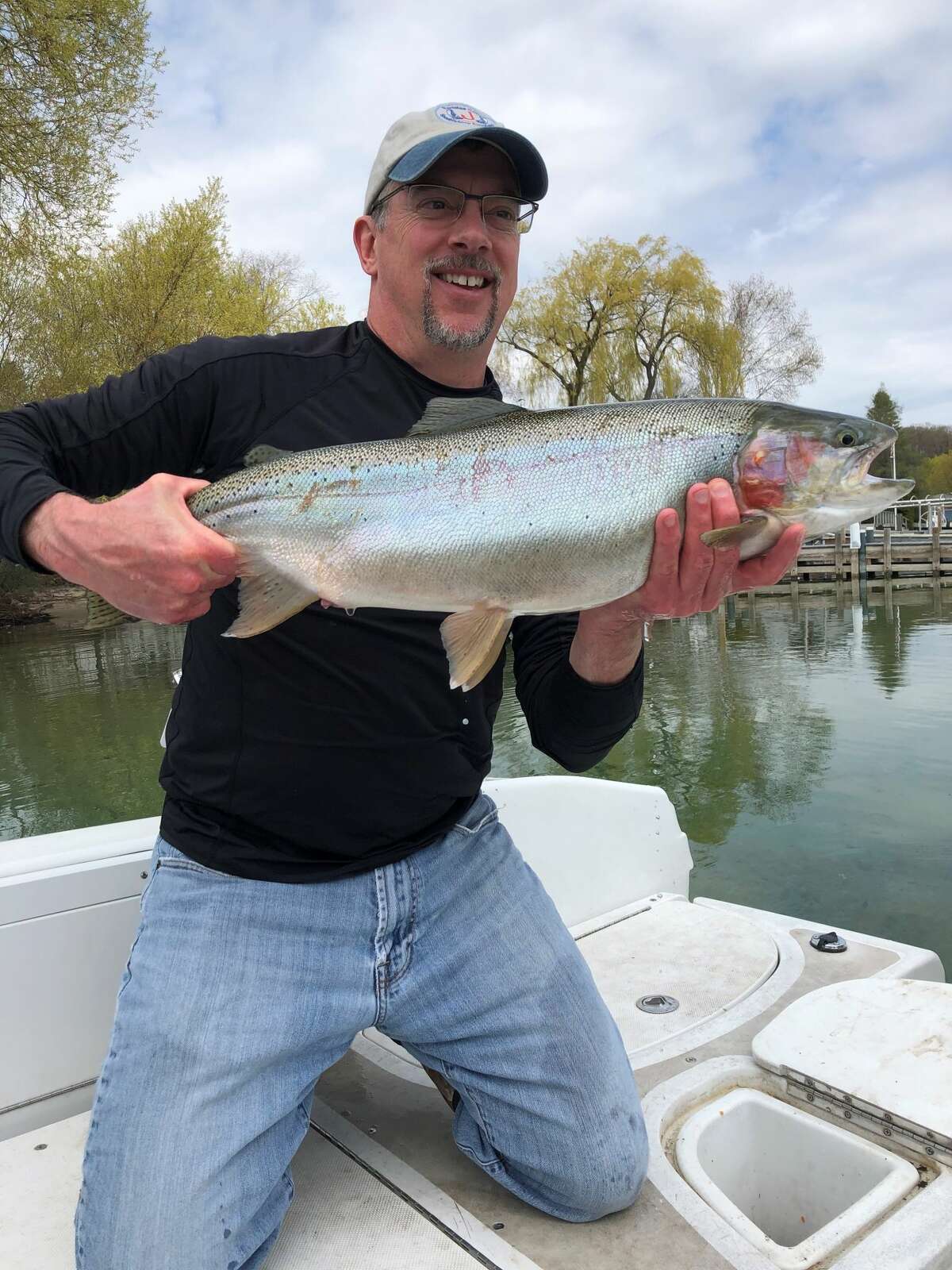 Randy Claramunt, Lake Huron Basin coordinator with the Michigan Department of Natural Resources, holds a steelhead trout. The small, ear-shaped adipose fin is located on top of the fish, to the left of the larger dorsal fin. On a clipped-fin fish, this fin would be missing.