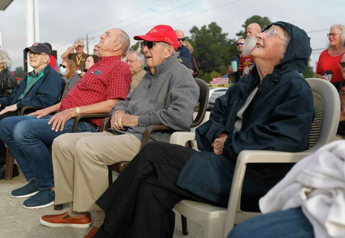 Celeste Graves, right, looks up at a large American flag during a flag dedication in her honor at Storage 105, Wednesday, Nov. 10, 2021, in Montgomery. The 102-year-old Magnolia resident served time as a radio operator for the Houston-based Women Air Force Service Pilots during World War II.