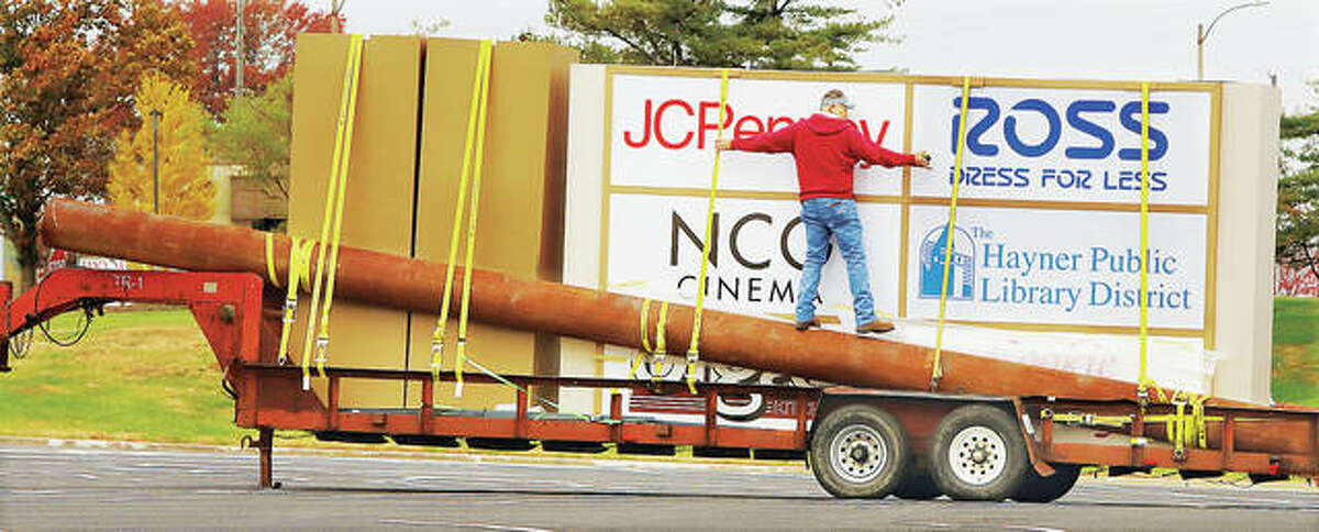 A worker from Knight Sign Industries Inc. moves around on a trailer Wednesday where a new lighted sign and the poles that will support it arrived on the south side of Alton Square Mall. The worker was measuring off an area in the grassy portion of mall property next to the Homer Admas Parkway. The sign carried the names of four large tenants of the mall including NCG Cinema. The new sign will be erected next to the parkway but west of the current sign and entrance to the mall.