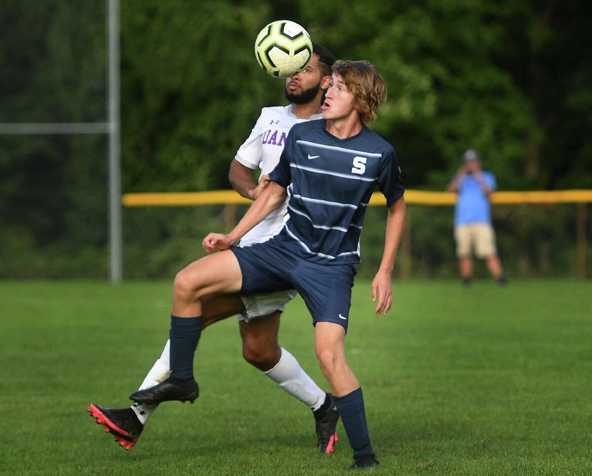 Danbury's Naidson Macedo and Staples' Wiill Adams compete for a header during their FCIAC boys soccer game at Staples High School in Westport, Conn. on Wednesday, September 22, 20i21.