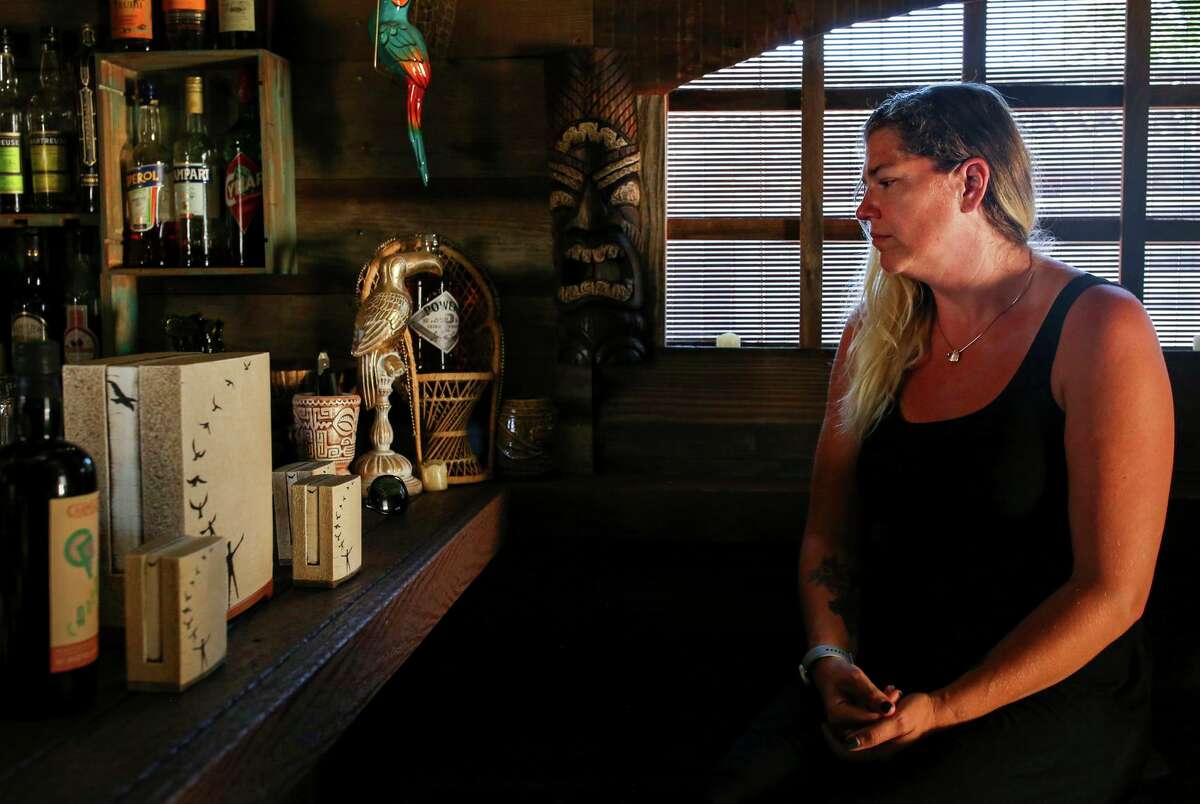 Terra Fritch looks at four urns containing the ashes of her husband in their San Jose home.