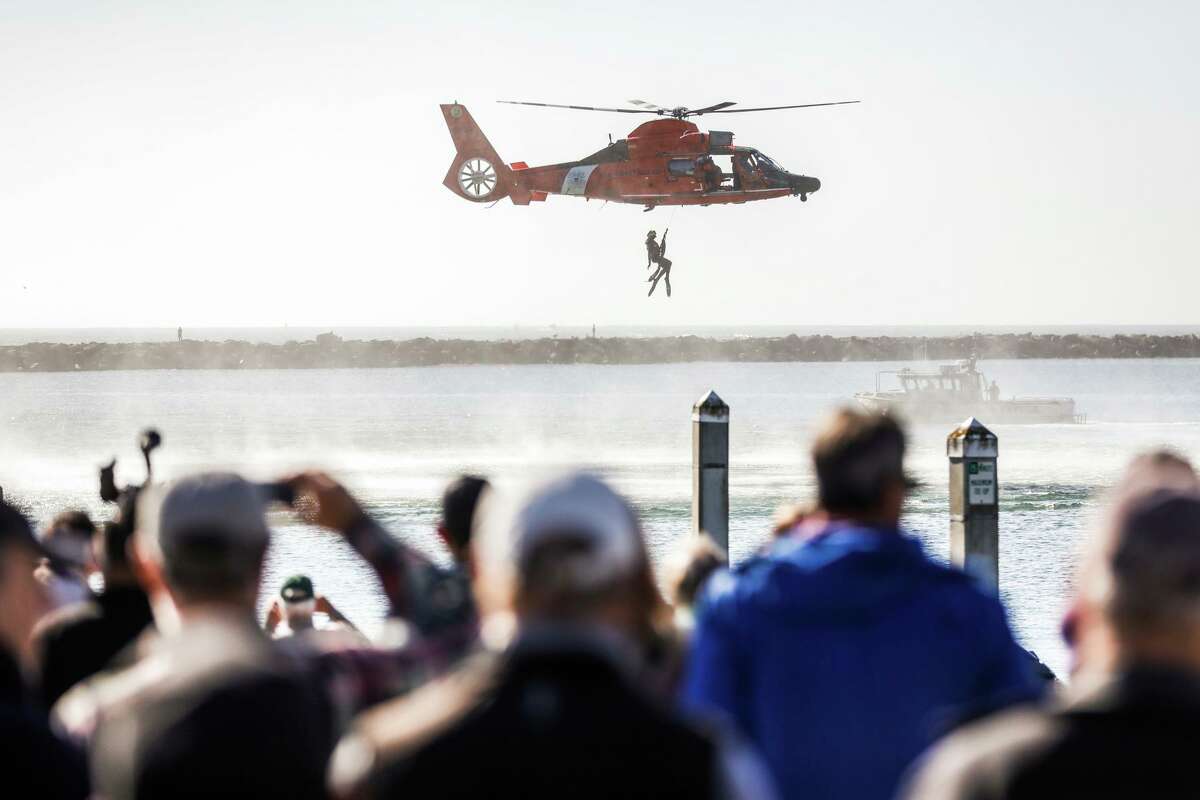 People watch a helicopter rescue demonstration to commemorate the loss of Arunay Pruthi during a Half Moon Bay event installing beach rescue equipment.