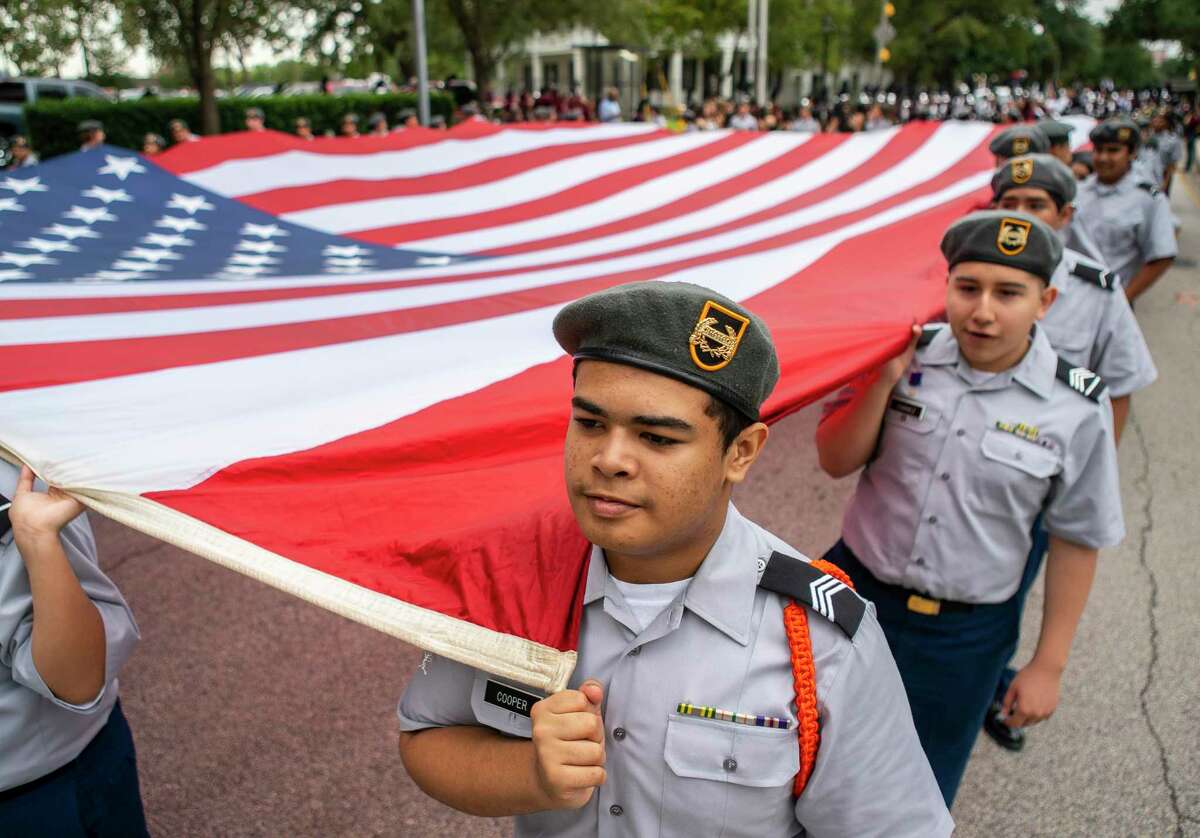 Tea Cooper, a sophomore at Heights High School, holds a giant American flag at the Houston Salutes American Heroes Veterans Day parade.