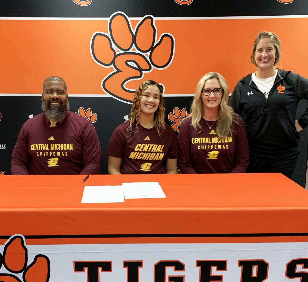 Edwardsville senior Sydney Harris, seated center, will play college basketball for Central Michigan. She is joined by her parents and EHS coach Caty Happe.