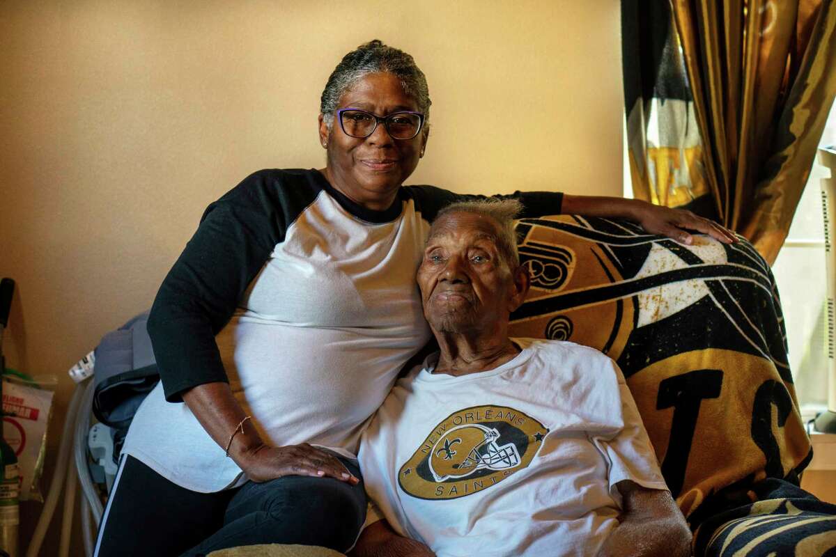 FILE - Vanessa Brooks poses for a portrait with her father Lawrence Brooks in his room at their home in New Orleans, on Sept. 8, 2021. For Veterans Day, a group of Democratic lawmakers is reviving an effort to pay the families of Black servicemen who fought on behalf of the nation during World War II for benefits they were denied or prevented from taking full advantage of when they returned home from war.