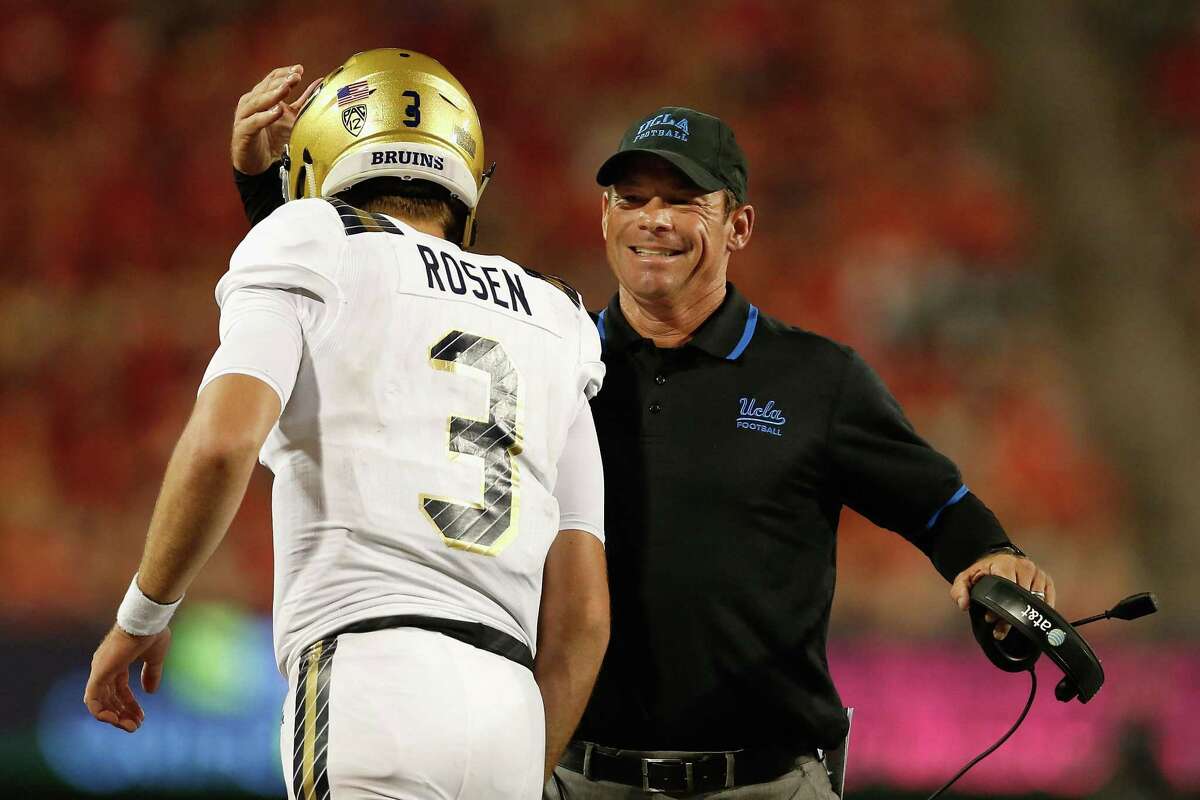 Head coach Jim Mora of the UCLA Bruins congratulates quarterback Josh Rosen #3 after Rosen scored on a eighth yard rushing touchdown against the Arizona Wildcats during the thrid quarter of the college football game at Arizona Stadium.
