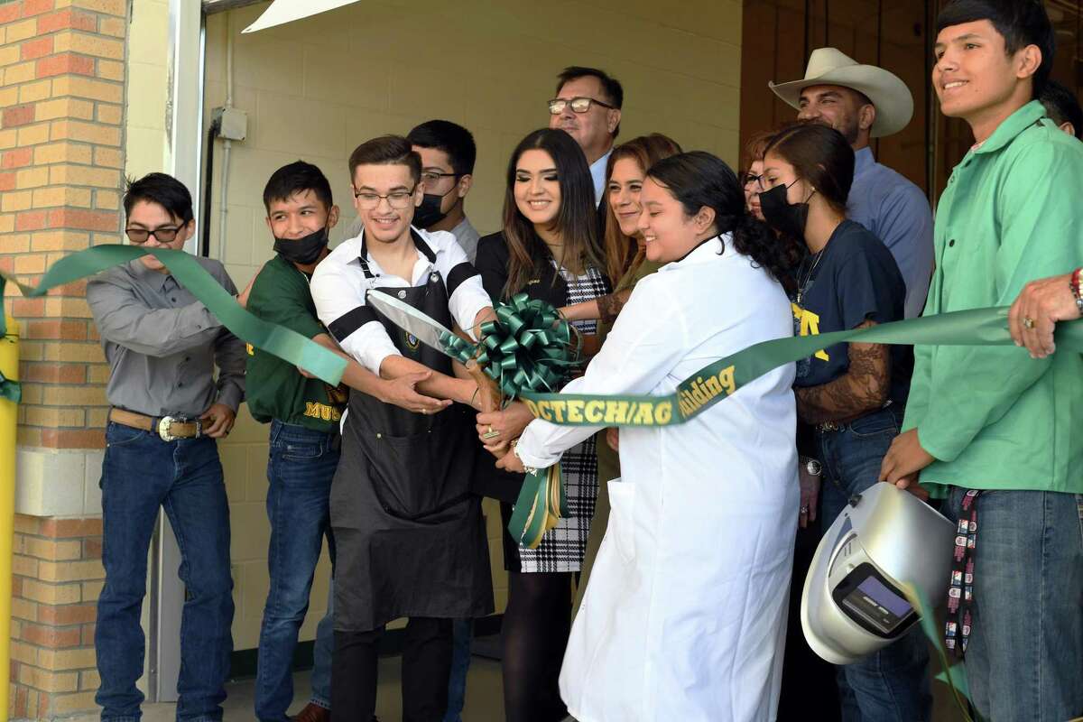 Nixon High School Principal Cassandra Mendoza is joined by city, district guests and vocational and agricultural program students to cut the ribbon of the new Vocational and Agriculture buildings.
