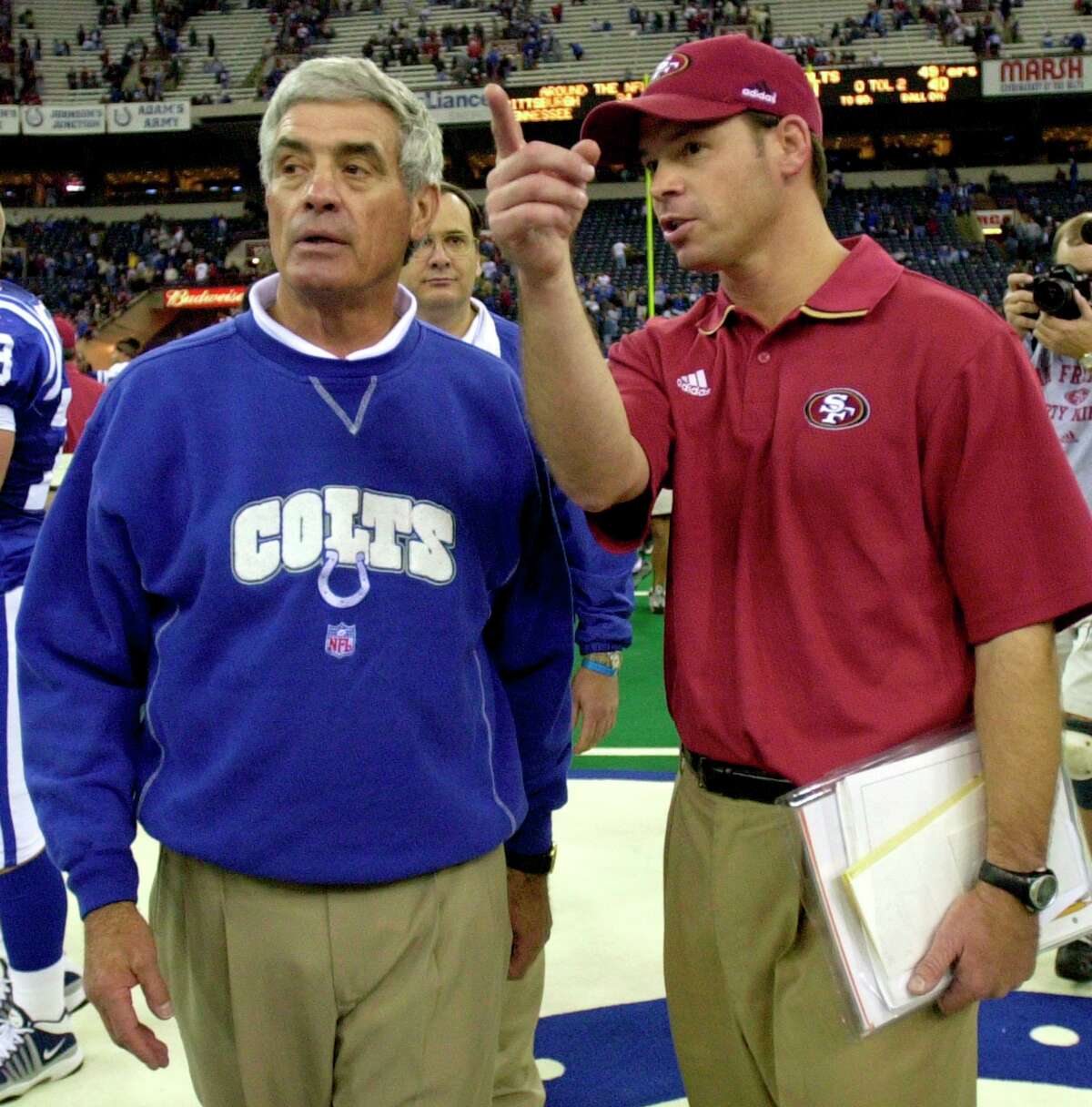 Indianapolis Colts head coach Jim Mora, left, is greeted by his son, San Francisco 49ers defensive coordinator Jim Mora following the game on Nov. 25, 2001, in Indianapolis. The younger Mora is back on the sideline as the new UConn football coach.