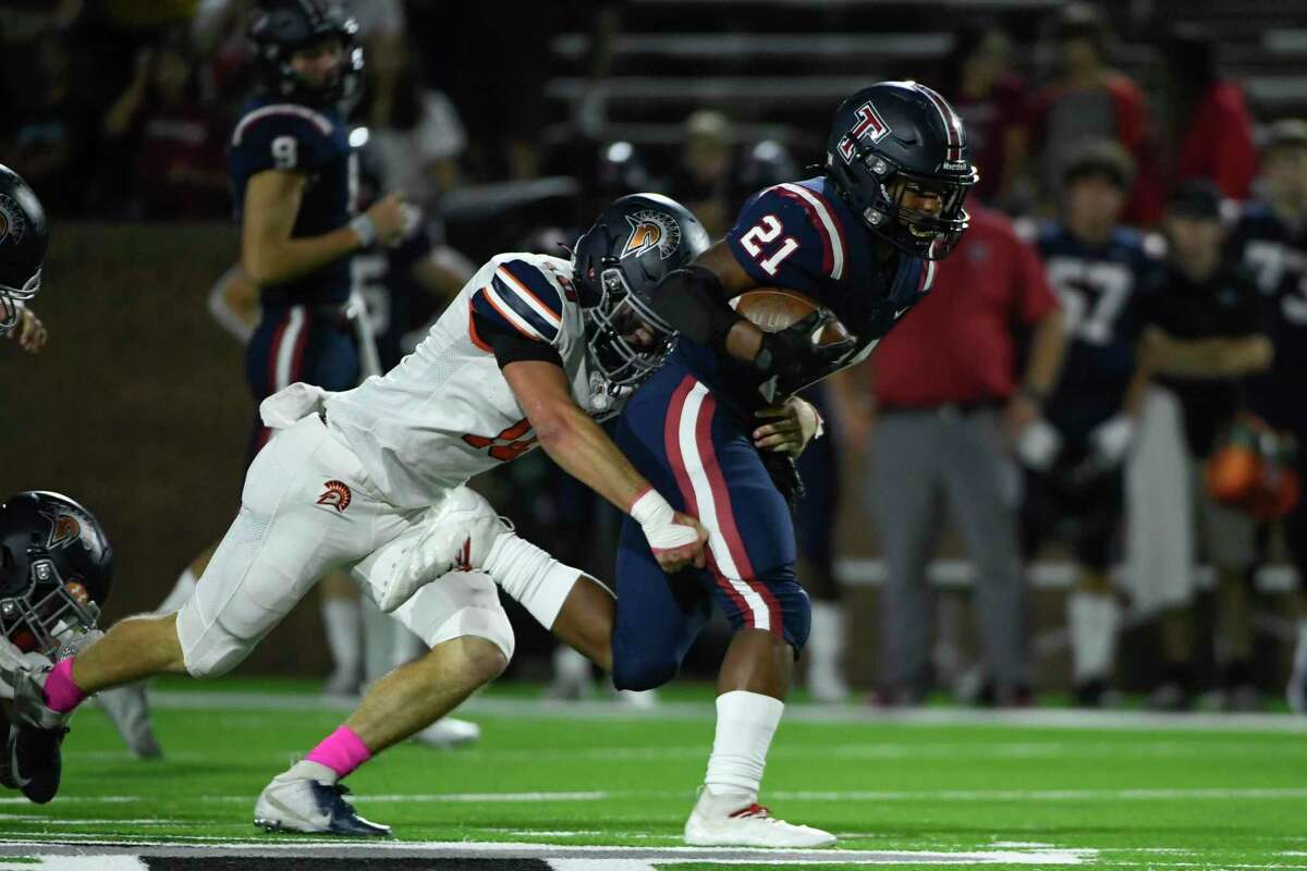 Tompkins’ Caleb Blocker (21) runs the ball against Seven Lakes’ Scott Stanford (10) during a District 19-6A high school football game Friday, Oct. 22, 2021, at Rhodes Stadium in Katy, Texas.