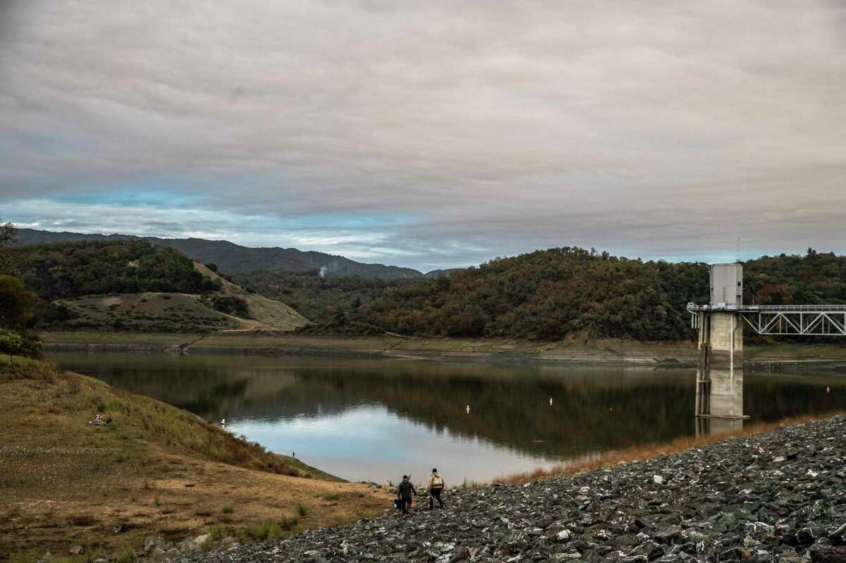 Fishermen descend a berm to fish in the severely depleted Lake Mendocino north of Ukiah.
