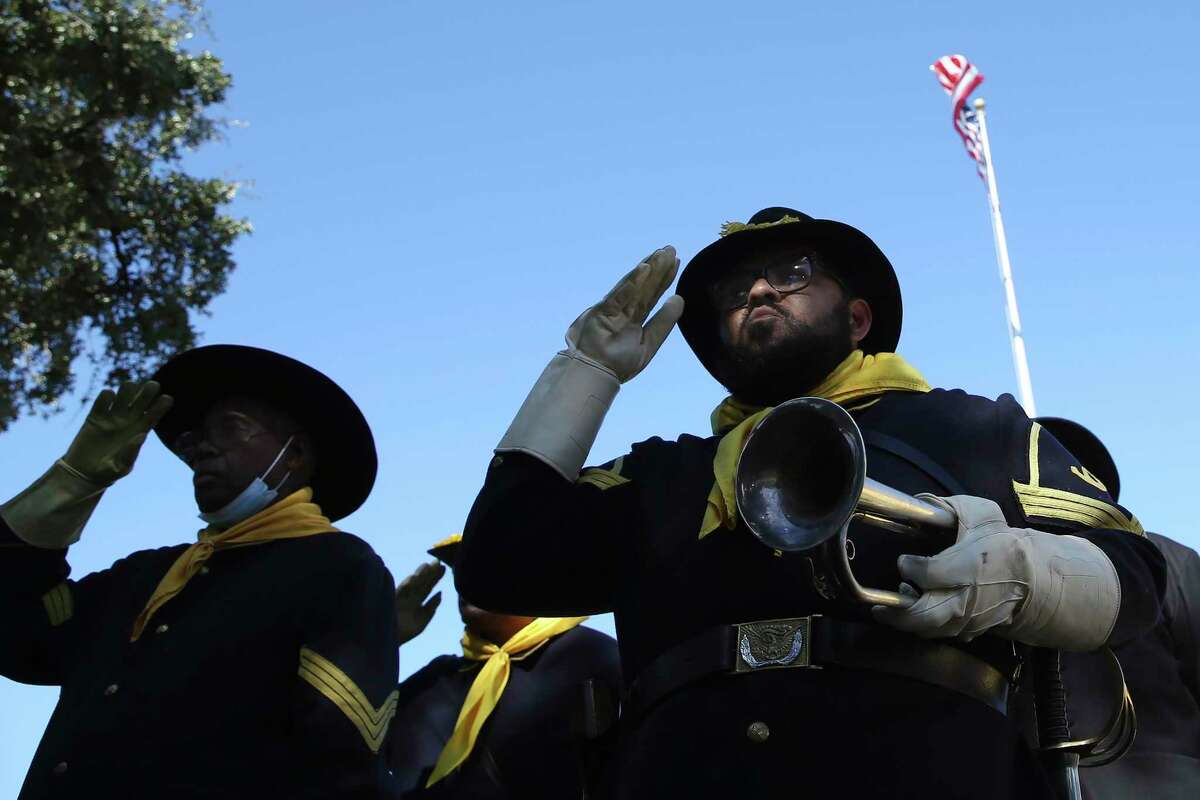 Dustin Mitchell, with the Bexar County Buffalo Soldiers, salutes the flag during a Veterans Day ceremony at San Antonio National Cemetery on Thursday, 2021.