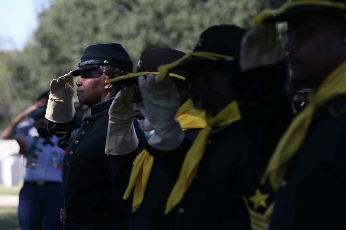 Bernice Brown, 62, with the Bexar County Buffalo Soldiers, salutes the flag during a Veterans Day ceremony at San Antonio National Cemetery on Thursday.