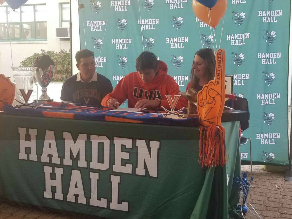 Ben James of Milford, middle, signs a National Letter of Intent to play college golf at the University of Virginia at Hamden hall Country Day on Nov. 11, 2021. Sitting with James are his parents, Don and Gretchen.