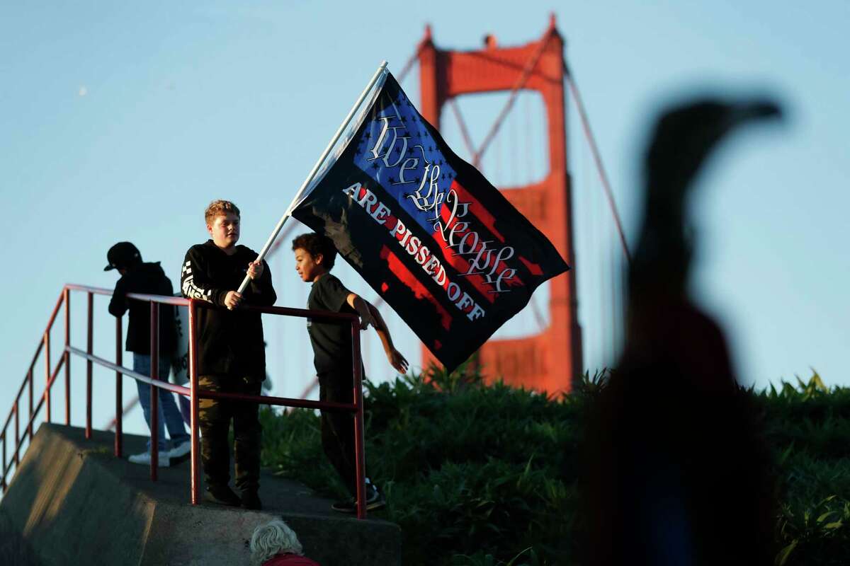 A young boy waves a flag as anti-vaxxers gather at the Golden Gate Bridge to protest mandates in San Francisco, Calif., on Thursday, November 11, 2021.