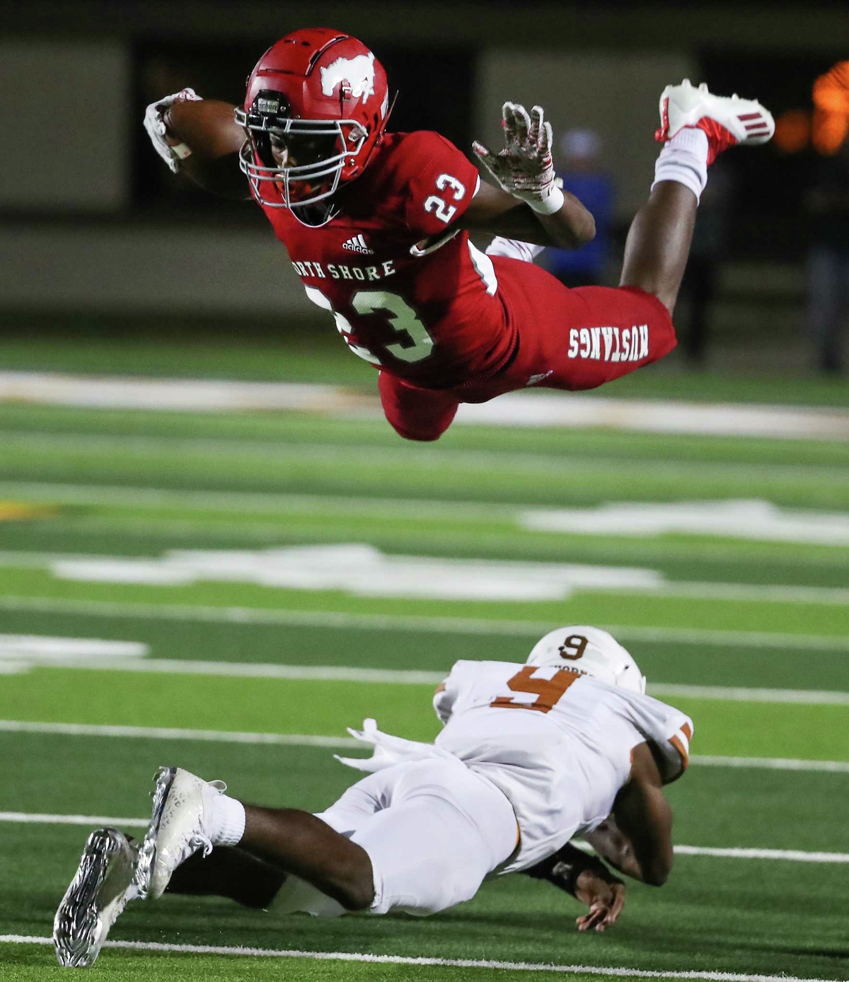 North Shore defensive back Evan Jackson (23) leaps over Dobie’s Cameron Gray (9) as he returns a punt during a Class 6A Division I bi-district playoff high school football game Thursday, Nov. 11, 2021 in Houston.