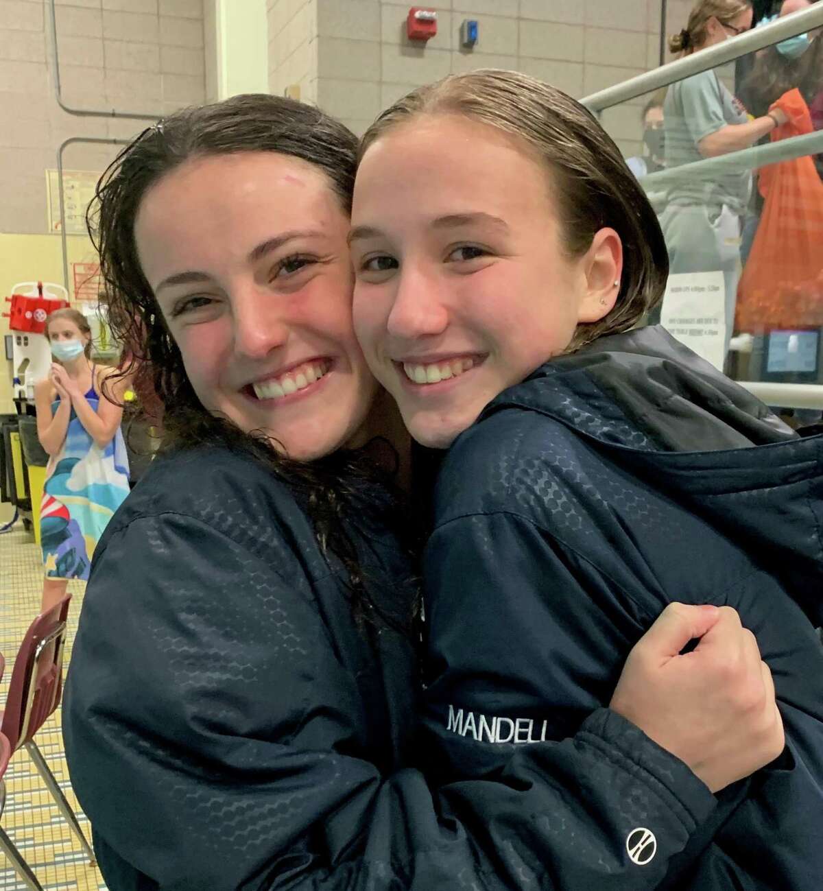 Class S dive champion Cali Mandell hugs sixth-place finisher and Weston teammate Francesca Sparagna.