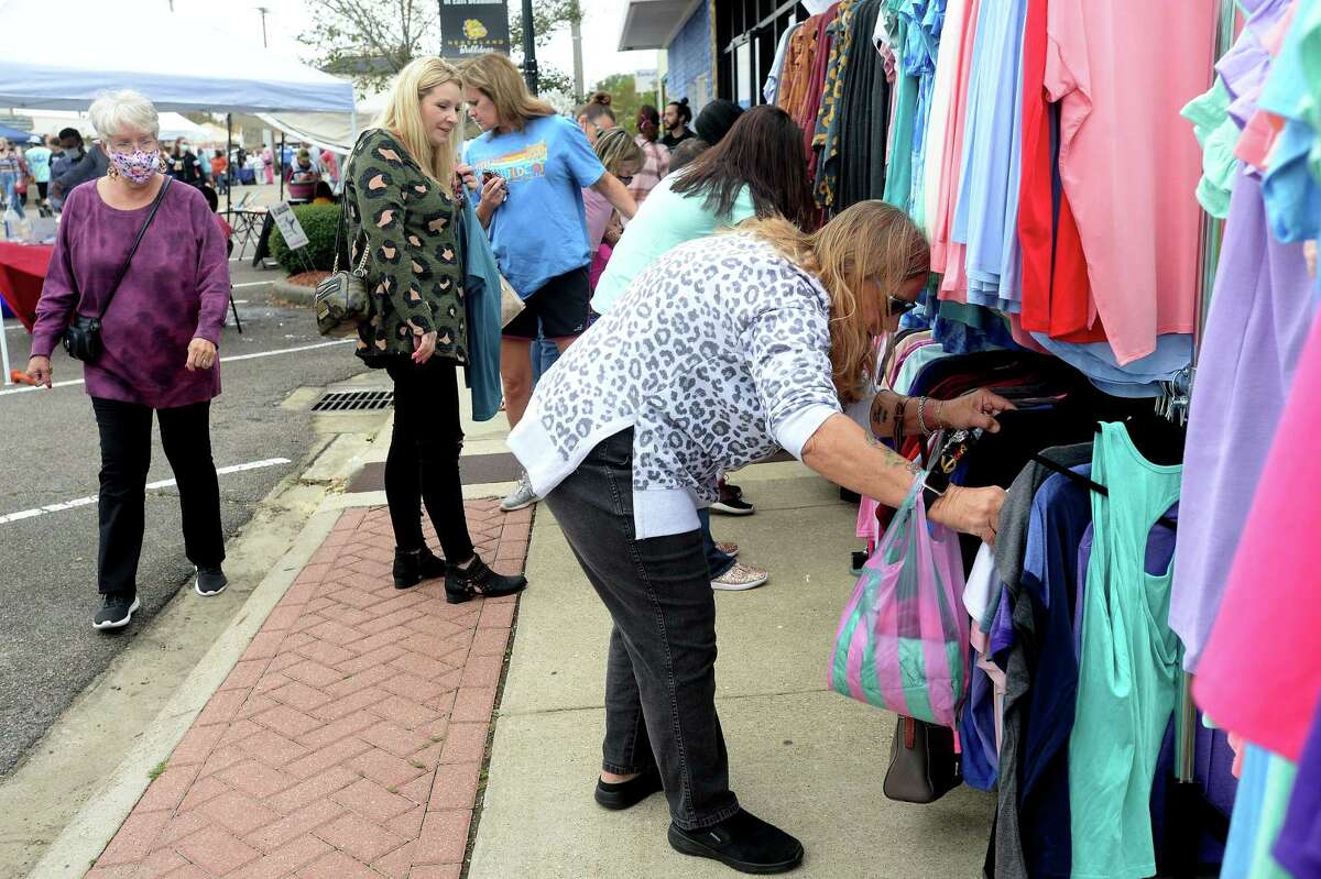 Barbara Parsons of Groves looks through racks of t-shirts as she joins the shoppers filling Boston Avenue, perusing the vendor booths and open shops during Nederland's Fall Fest Saturday. Photo taken Saturday, October 17, 2020 Kim Brent/The Enterprise