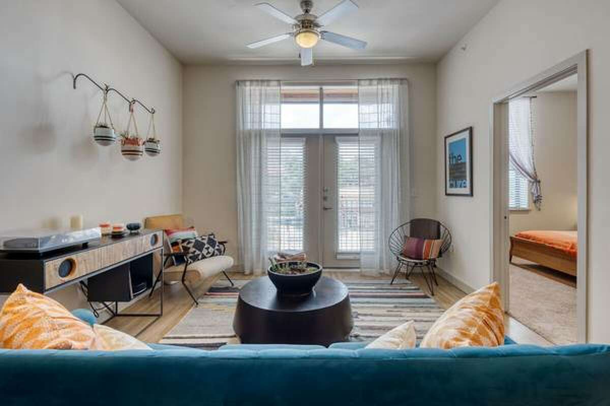 The living room has doors that open up to a balcony overlooking the pool.
