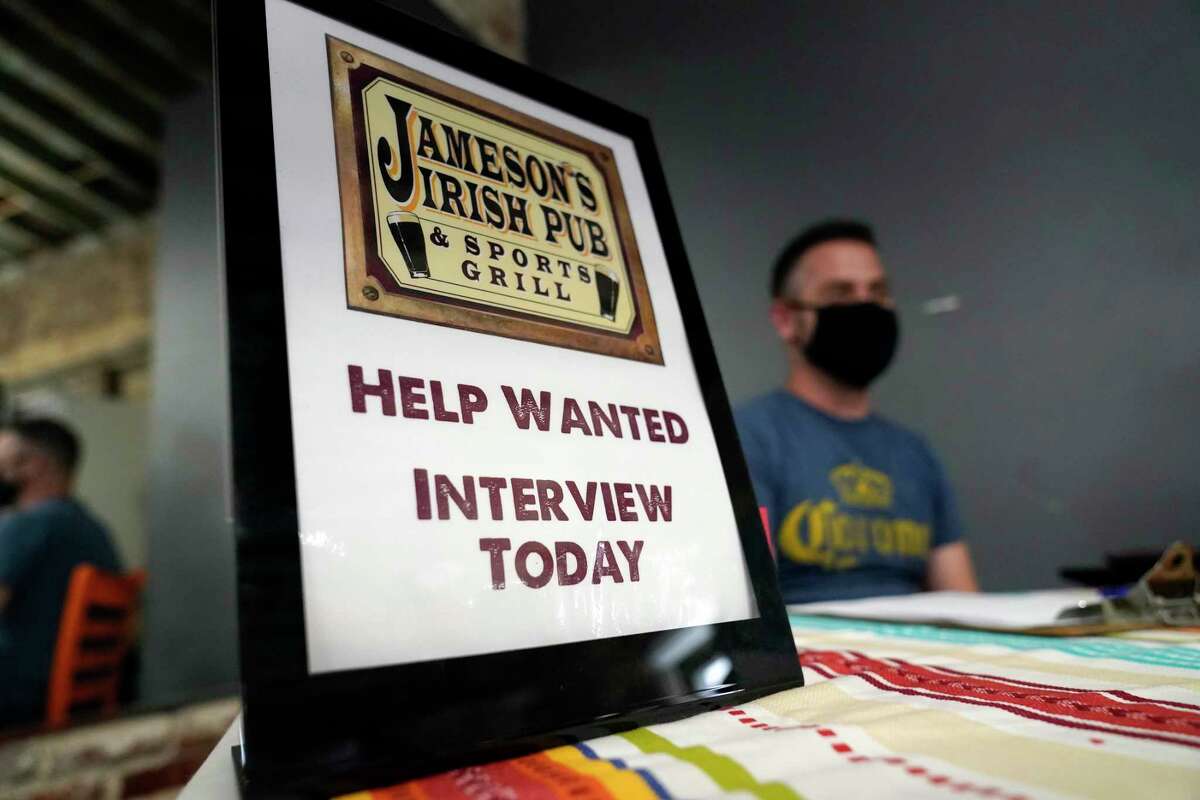 FILE - A hiring sign is placed at a booth for Jameson's Irish Pub during a job fair Wednesday, Sept. 22, 2021, in the West Hollywood section of Los Angeles. Americans quit their jobs at a record pace for the second straight month in September, while businesses and other employers continued to post a near-record number of available jobs.