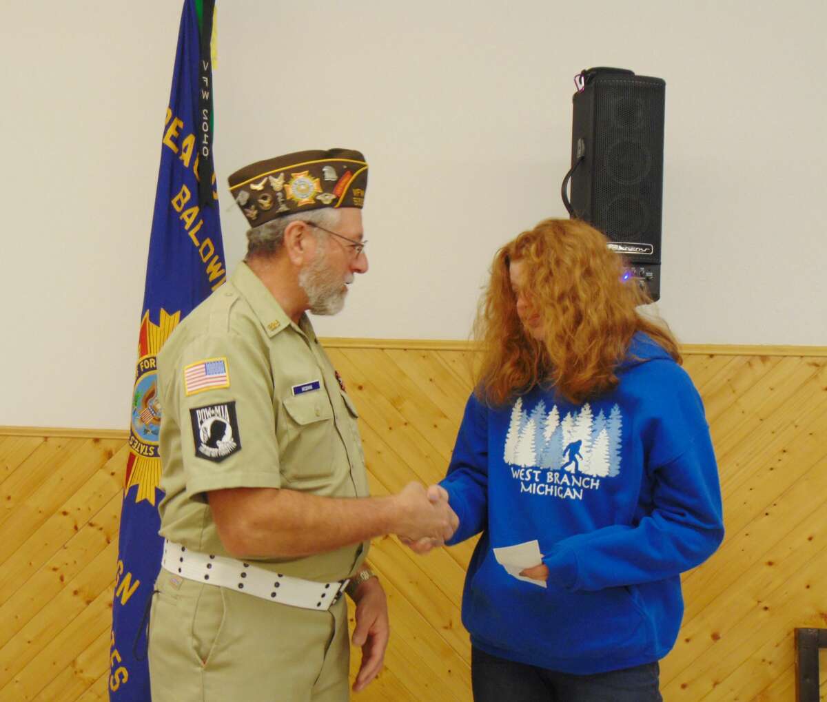 VFW Post Commander Dave Woodman congratulated 8th-grader Daniela Dienes for winning the Patriot Pen essay. 