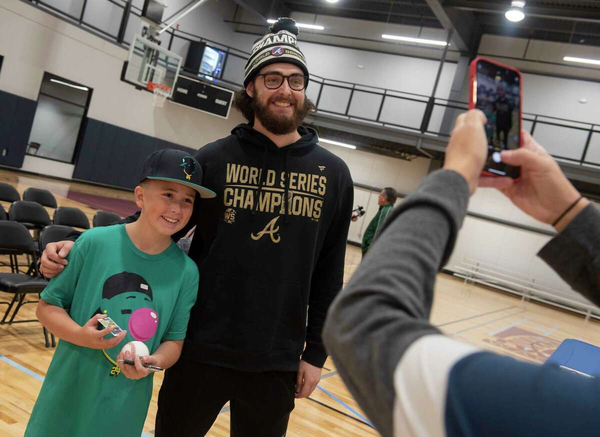 Jessica Aiezza, right, takes a photo of her son Maddox Aiezza, 10, of Halfmoon with Shenendehowa graduate and Atlanta Braves pitcher Ian Anderson after he talked about his season that ended with a World Series title at the Impact Athletic Center on Friday, Nov. 12, 2021 in Clifton Park, N.Y. Maddox had Anderson sign his baseball and baseball card.