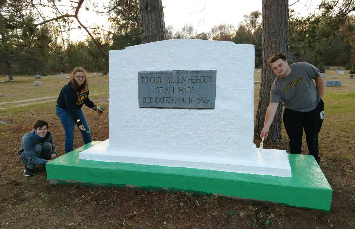 Evan Wogatzke, Nicole McGahey and Adam McClure are pictured with the final result of the restoration.