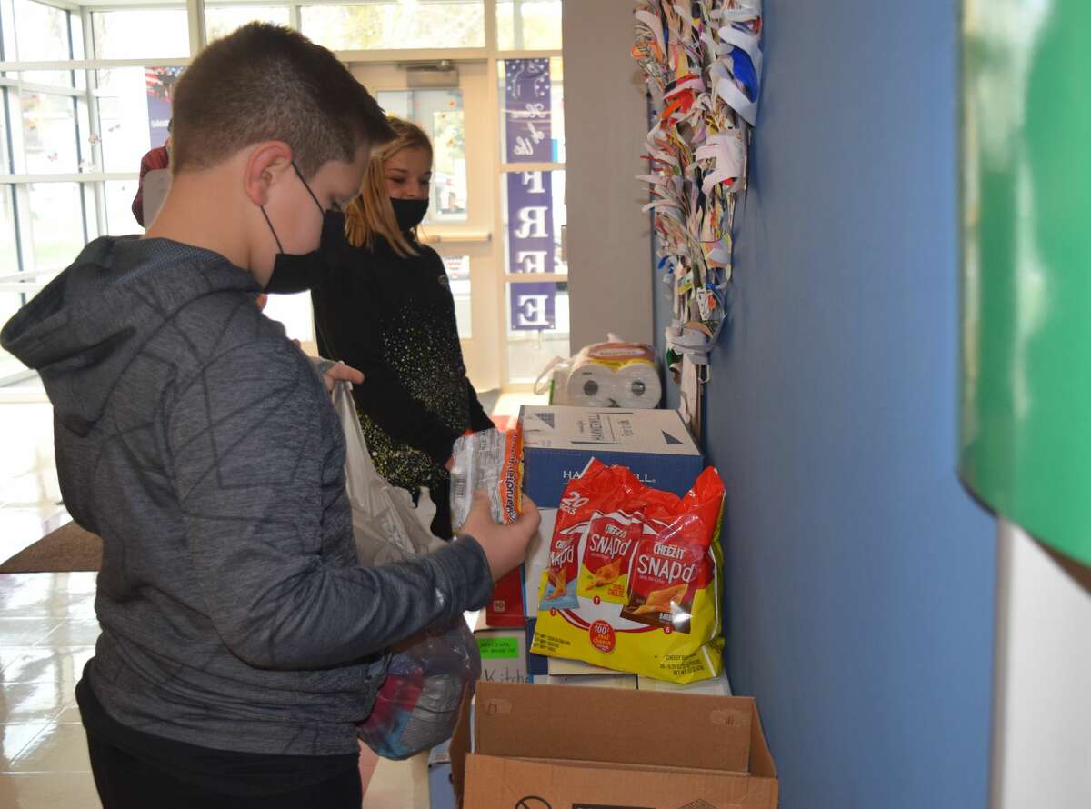Griffin Saxer (front) and Vienna Lindsey spend time Thursday organizing supplies collected by South Jacksonville Elementary School students. 