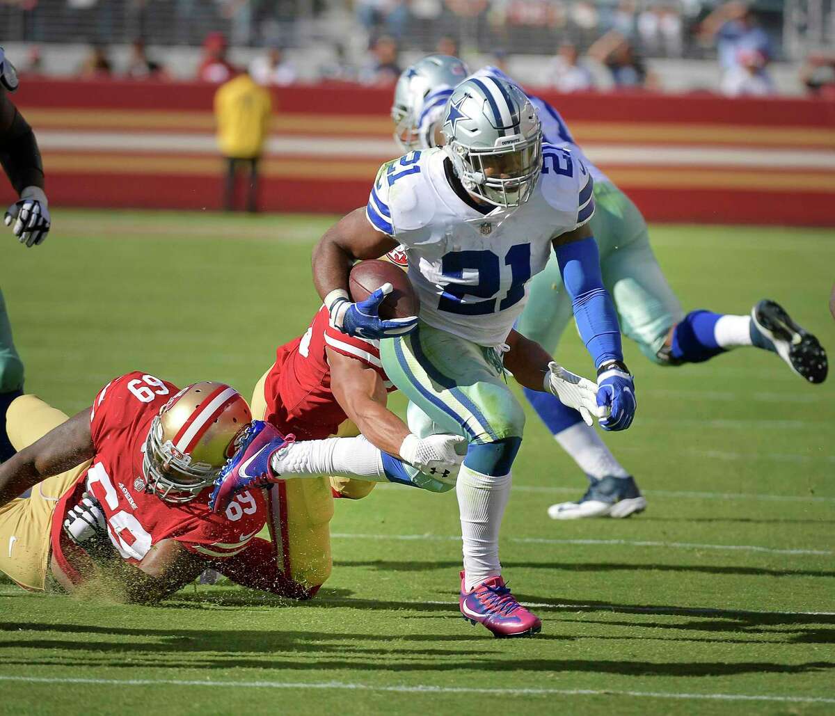Dallas Cowboys running back Ezekiel Elliott (21) picks up another first down as San Francisco 49ers defensive tackle Tony McDaniel (69) and strong safety Eric Reid (35) can't stop him during the fourth quarter as the Cowboys beat the 49ers 40-10 on Sunday, Oct. 22, 2017 at Levi's Stadium in Santa Clara, Calif. (Max Faulkner/Fort Worth Star-Telegram/TNS)