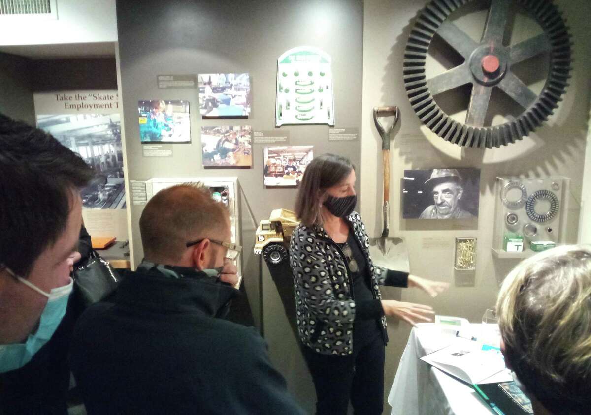 Dymax employees spent time at the Torrington Historical Society on Nov. 4. Curator Gail Kruppa, center, discusses a display with the group.