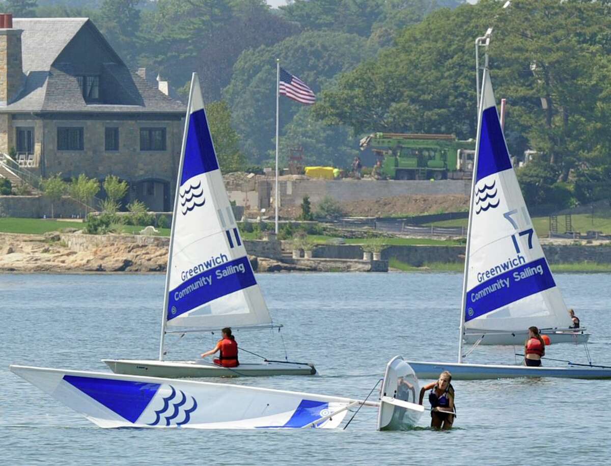 A Greenwich Community Sailing School student, center, practices capsize recovery while taking part in a sailing class in Greenwich Cove in 2015. The business, which has been in town for 24 years. will not continue in 2022 as a lease dispute between the two sides has ended the relationship.