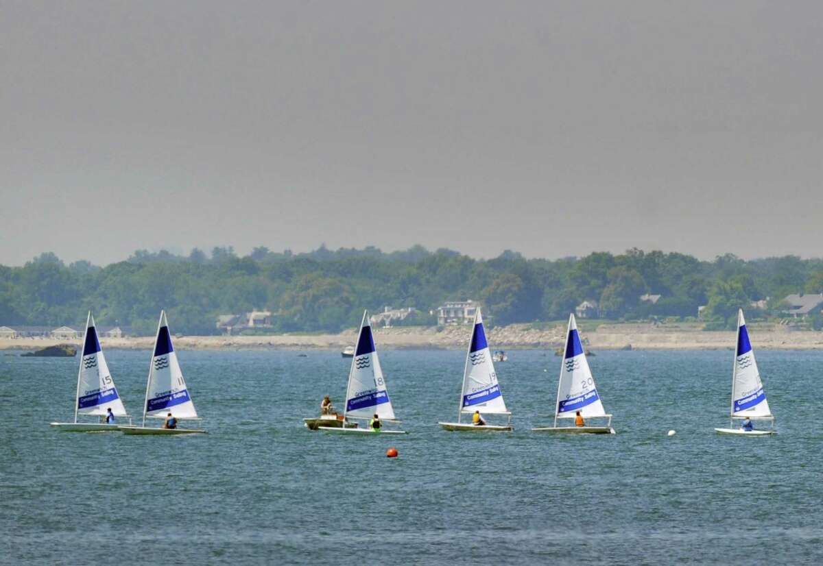A fleet of boats from Greenwich Community Sailing can be seen in formation just out of Greenwich Cove in Long Island Sound just off the shore of Greenwich Point, Conn., Friday, July 20, 2018.